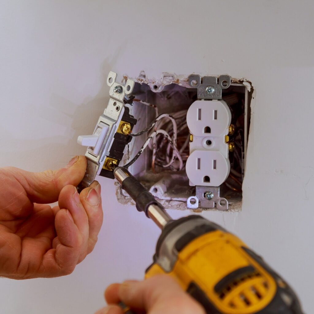 Electrician installing a power receptacle