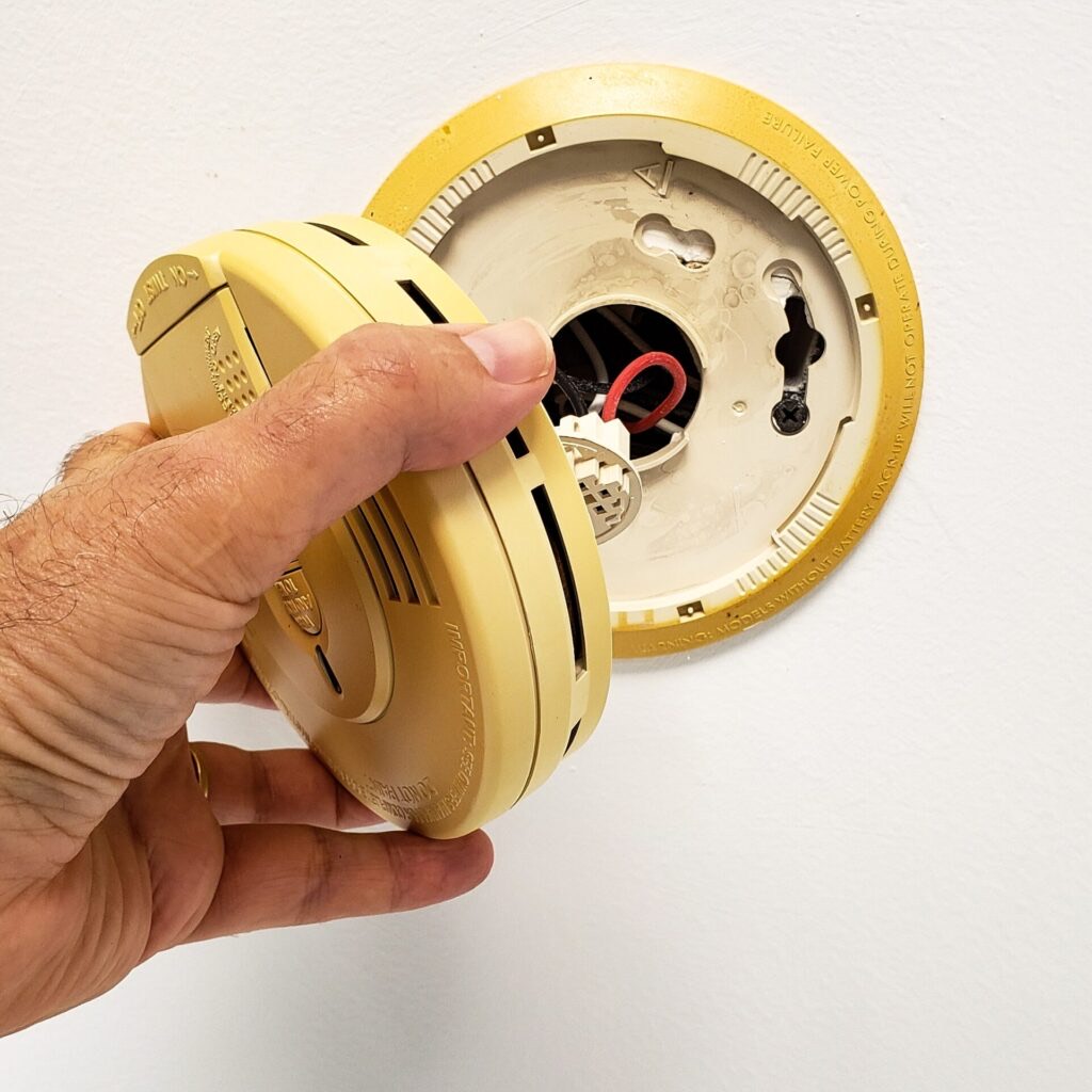 Built-in smoke alarm being opened for service