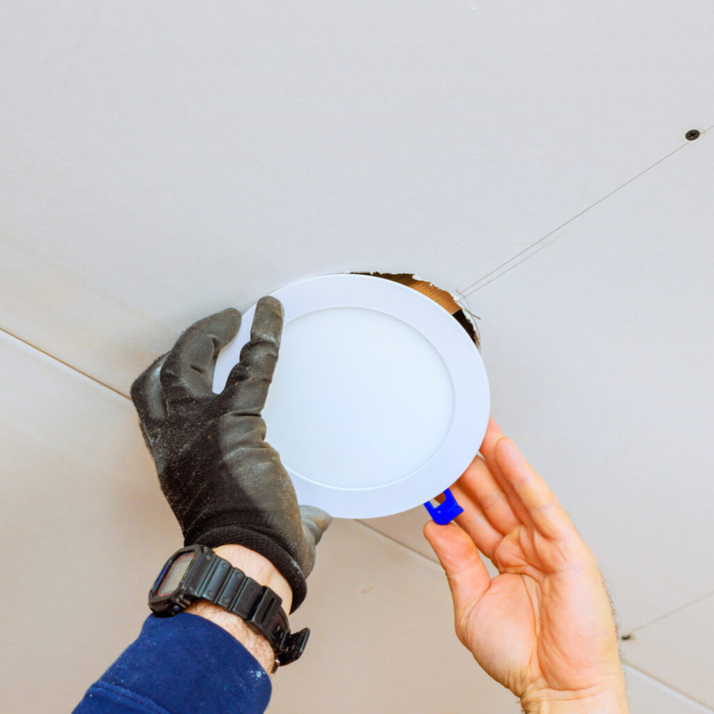 Stock image of a worker installing recessed light